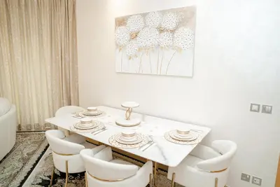 a white dining room with a white table and chairs at 2BDR Luxury Apartment in Palm in Dubai