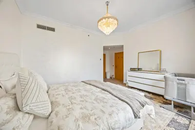 a white bedroom with a bed and a mirror at 2BDR Luxury Apartment in Palm in Dubai