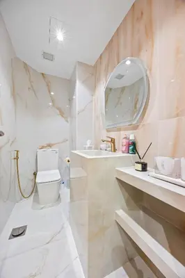 a bathroom with a toilet and a sink and a mirror at 2BDR Luxury Apartment in Palm in Dubai