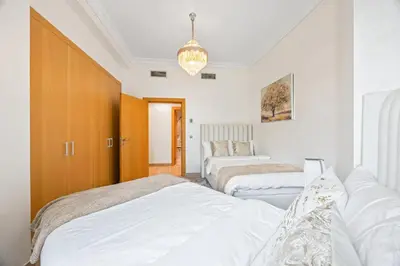 a bedroom with two beds and a chandelier at 2BDR Luxury Apartment in Palm in Dubai