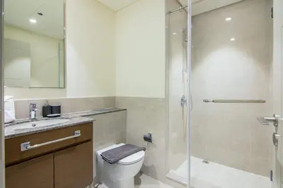 a bathroom with a shower and a toilet and a sink at Forte, Downtown- Elegant 1-BR in Dubai