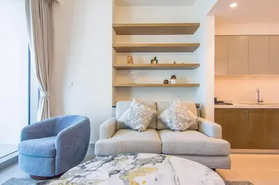 a living room with a couch and a chair at Forte, Downtown- Elegant 1-BR in Dubai