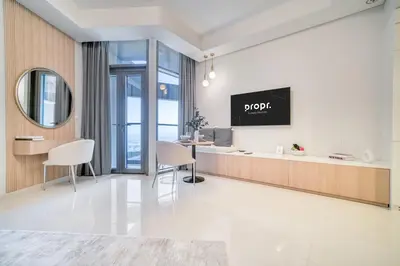 a living room with a tv on a wall at Cozy High-Floor Studio with Amazing Views in Dubai
