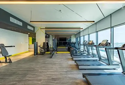 a gym with a row of treadmills and machines at Cozy High-Floor Studio with Amazing Views in Dubai