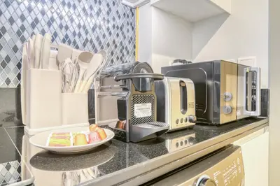 a kitchen counter with a toaster and a coffee maker at Cozy High-Floor Studio with Amazing Views in Dubai