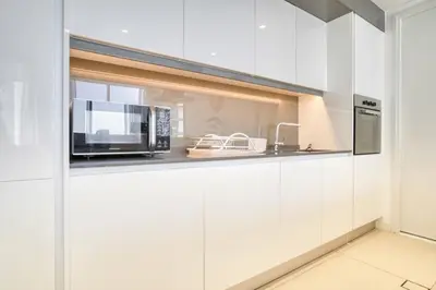 a kitchen with white cabinets and a microwave at Shadow Of The Sun by Lagom in Dubai