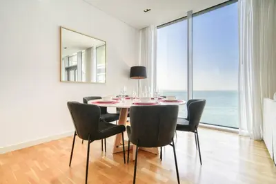 a dining room with a table and chairs and a large window at Shadow Of The Sun by Lagom in Dubai