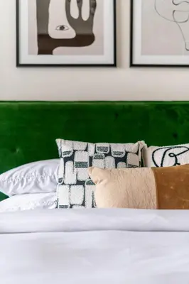 a bed with a green headboard and pillows on it at GuestReady - Marvellous stay in Marina | Canal View in Dubai