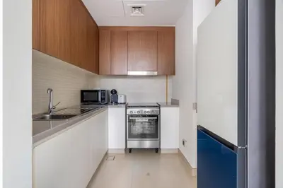 a kitchen with white cabinets and a blue oven at GuestReady - Marvellous stay in Marina | Canal View in Dubai