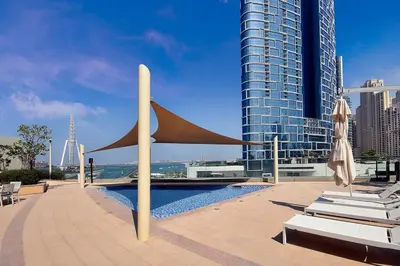 a pool with chairs and umbrellas next to a building at GuestReady - Marvellous stay in Marina | Canal View in Dubai