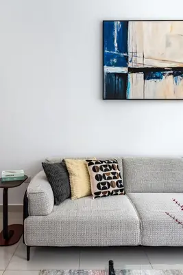 a living room with a couch and a painting on the wall at ShoresInn - Charming 1BR with Marina Views in Dubai