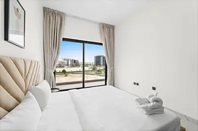 a bedroom with a white bed and a large window at Amazing 1 Bdr luxury residence Dubai Arjan in Dubai