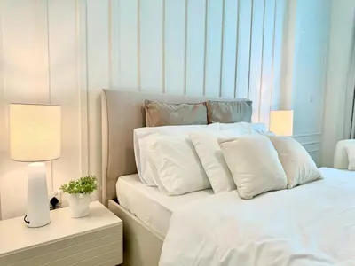 a bed with white sheets and pillows in a room at Amazing 1BR in Dubai Marina with Luxury Interiors in Dubai