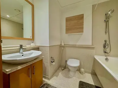 a bathroom with a sink and a toilet and a tub at Amazing 1BR in Dubai Marina with Luxury Interiors in Dubai