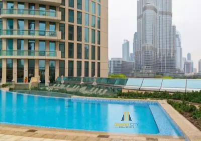 a large swimming pool in front of a tall building at Luxurious 2 Bed Next to Burj Khalifa, Hosted by Desert City Stays in Dubai