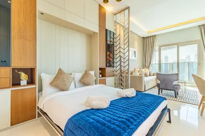 a bedroom with a large bed and a living room at Deluxe One-Bedroom Apartment in Business Bay with Burj Khalifa and Canal View in Dubai