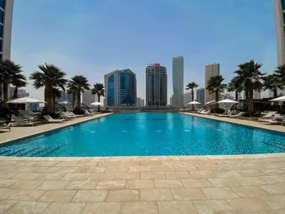 a swimming pool with a city skyline in the background at Deluxe One-Bedroom Apartment in Business Bay with Burj Khalifa and Canal View in Dubai