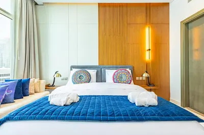 a bedroom with a blue bed with towels on it at Deluxe One-Bedroom Apartment in Business Bay with Burj Khalifa and Canal View in Dubai