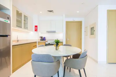 a kitchen with a white table and chairs at Creekside, Creek Harbour 1 BDR in Dubai
