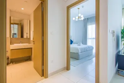 a bedroom with a bed and a bathroom with a mirror at Creekside, Creek Harbour 1 BDR in Dubai