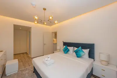 a bedroom with a large white bed with blue pillows at Spacious 1br in Ahad, Business Bay in Dubai