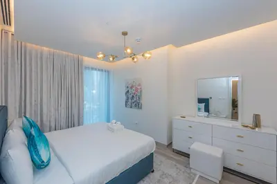 a bedroom with a bed and a dresser and a mirror at Spacious 1br in Ahad, Business Bay in Dubai