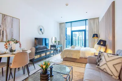 a living room with a bed and a dining room at Marquise Square Studio, Business Bay in Dubai