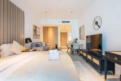 a bedroom with a large bed and a living room at Marquise Square Studio, Business Bay in Dubai