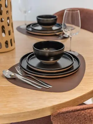 a table with black plates and silverware on a table at Prestigious 2BR-Noura Tower- Business Bay in Dubai