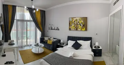 a white bedroom with a bed and a couch at Millennium Binghatti Residence in Dubai