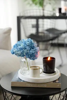 a table with a vase of blue flowers and two cups at Luxury 1Br apartment, Canal view in Dubai
