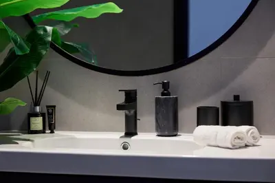 a bathroom sink with two faucets and a mirror at Luxury 1Br apartment, Canal view in Dubai