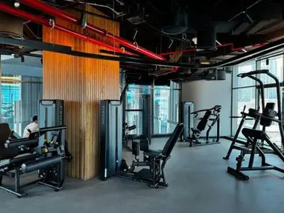 a gym with several treadmills and chairs in a room at Luxury 1Br apartment, Canal view in Dubai