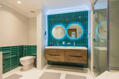 a bathroom with a sink and a toilet and green tiles at Fairmont Residences, Exquisite 2BR Luxury Retreat in Dubai