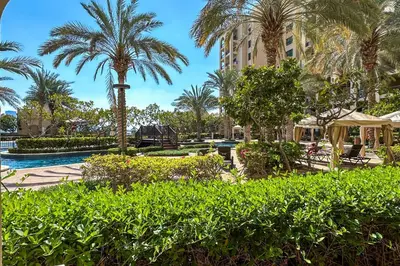 a resort with a pool and palm trees and a building at Fairmont Residences, Exquisite 2BR Luxury Retreat in Dubai