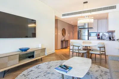a living room with a table and a kitchen at Address Residential 2 BDR, JBR in Dubai