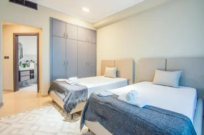 a bedroom with two beds and a bathroom at Marina Crown 2 BDR, Marina in Dubai