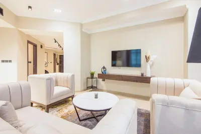 a living room with white furniture and a tv at Marina Crown 2 BDR, Marina in Dubai