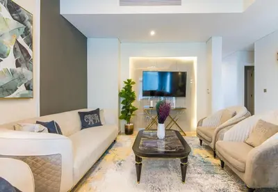 a living room with two couches and a tv at Reem 3 BDR Villa in Dubai