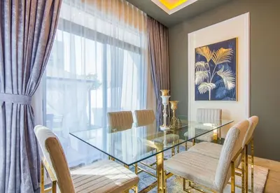 a dining room with a glass table and chairs at Reem 3 BDR Villa in Dubai