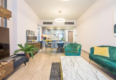 a living room with a green couch and a table at MBL Residence 2 BDR, JLT in Dubai
