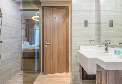 a bathroom with two sinks and a wooden door at MBL Residence 2 BDR, JLT in Dubai