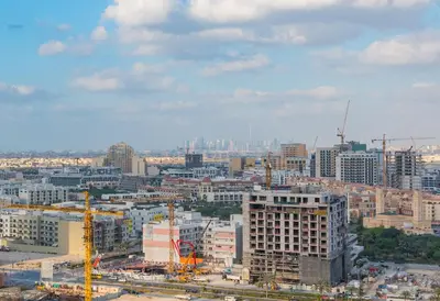 a view of a city with construction equipment and buildings at Bloom Heights 1 BR, JVC in Dubai