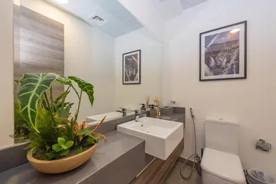 a bathroom with a sink and a toilet and a mirror at Bloom Heights 1 BR, JVC in Dubai