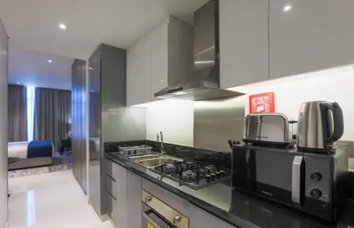 a kitchen with a sink and a stove top oven at Damac Maison Prive, Business Bay- Gorgeous Studio in Dubai