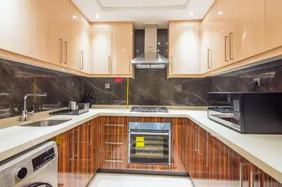 a kitchen with wooden cabinets and a stove top oven at Elite 1 BR, Downtown in Dubai
