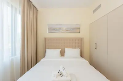 a bedroom with a bed with two shoes on it at Park Heights 1 BR, Dubai Hills in Dubai