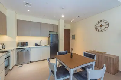 a kitchen and dining room with a table and chairs at Park Heights 1 BR, Dubai Hills in Dubai