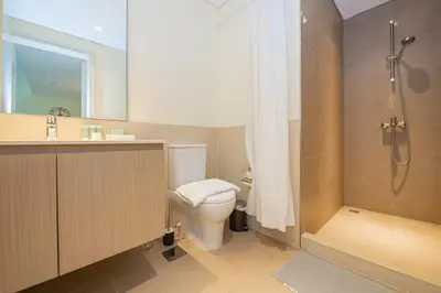 a bathroom with a toilet and a shower and a sink at Park Heights 1 BR, Dubai Hills in Dubai
