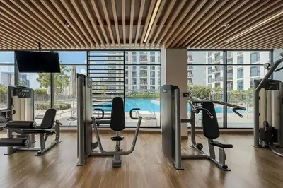 a gym with cardio equipment and a large window at Premium Apartments at Executive Residences in Dubai